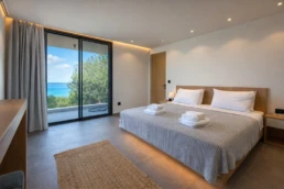 Luxury bedroom with sea view and floor-to-ceiling windows at Astria Villas rental