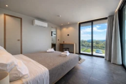 Luxury master bedroom with sea view balcony at Astria Villas rental