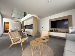 Villa 2 in Vourvourou, Halkidiki, featuring an open-plan living room with sofa, armchairs, TV, and kitchen area.
