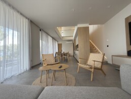 Villa 2 in Vourvourou, Halkidiki, featuring a living area with sofa and chairs in a bright, open-plan layout.